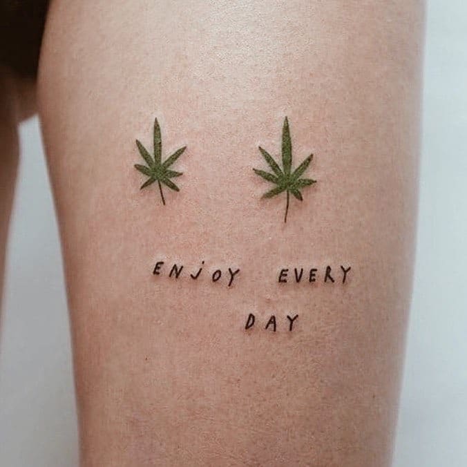 tatuagem discreta de maconha com escrito "enjoy every day"